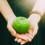 person holding green apple